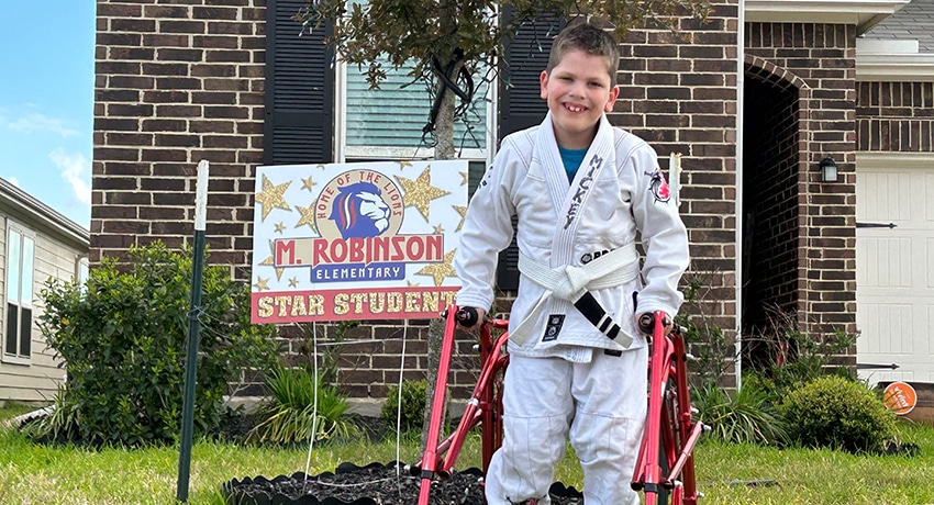 Mickey Wright stands in front of his house that displays a Star Student sign