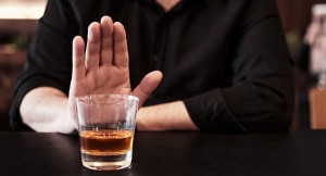 Man holds up hand to pass on shot of alcohol