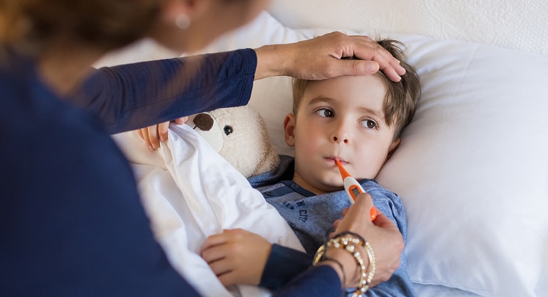 Mother takes temperature of sick son