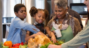 Grandmother next to two children at Thanksgiving table.