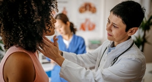 Doctor checking for thyroid symptoms