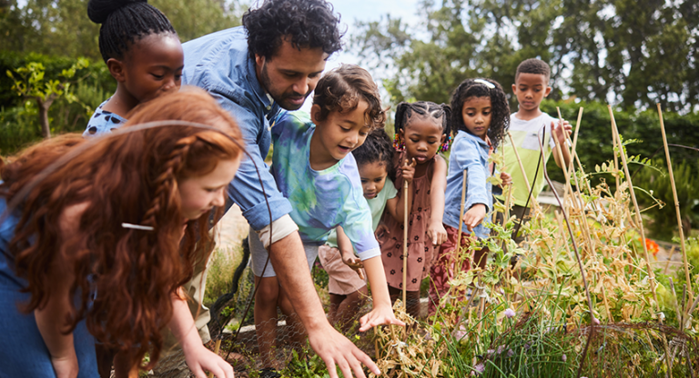 Adult teaching children about a garden.